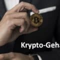 Geschäftsmann im Anzug hält Bitcoin-Münze in der Hand